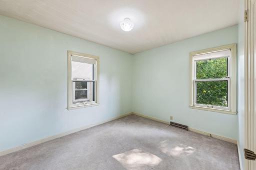 Main-level bedroom with two windows providing natural light and flexible space for a bedroom, guest room, or home office.