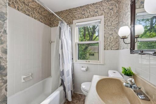 Convenient main-level full bathroom with tub/shower combination and a window for natural light.