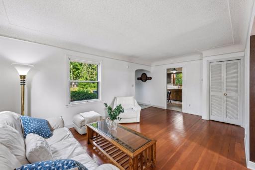 Spacious main-level living room with an open layout, flexible furniture arrangement, and easy access to the kitchen and dining area.