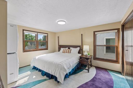 Spacious upper-level primary bedroom filled with natural light and featuring two closets for generous storage.