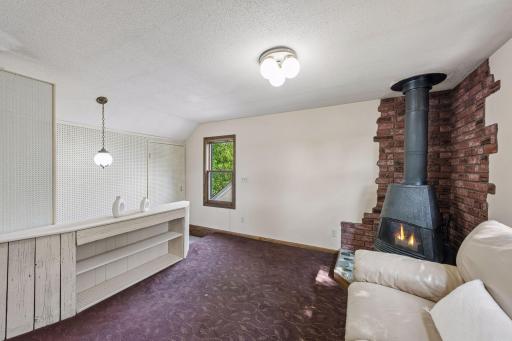 Another view of the upper-level den featuring a distinctive accent wall and built-in shelving, offering flexible space for reading, relaxing, or a home office.