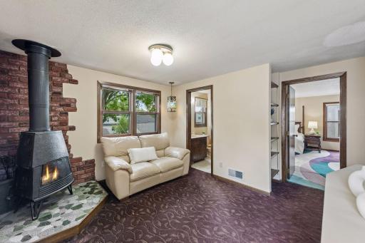 Cozy upper-level den with a freestanding wood-burning fireplace and natural lightâa great space for relaxing, reading, or unwinding at the end of the day.