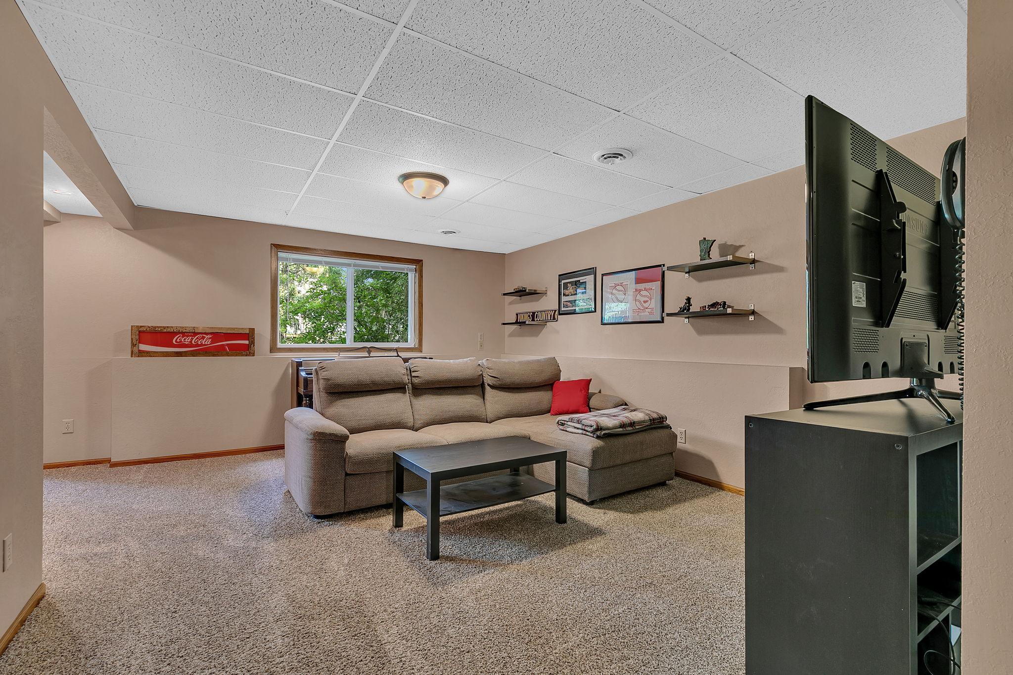 Another view of the lower-level living room, where the walkout design brings in an abundance of natural light and creates a bright, inviting space.