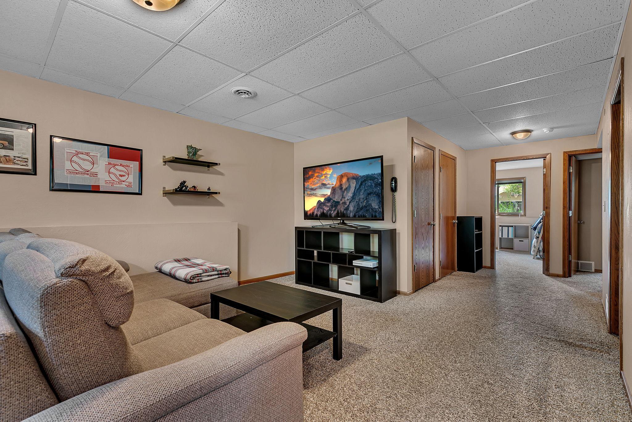 The lower level offers another spacious living area with a walkout to the backyard, adding even more space for relaxing and entertaining.