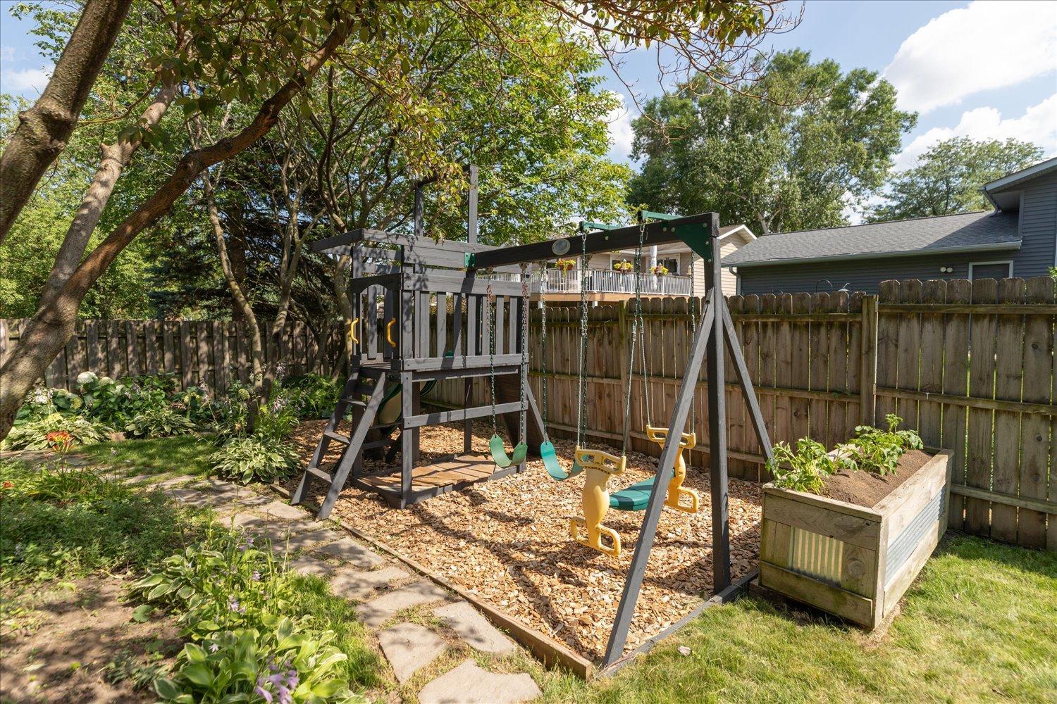 Fenced in back yard filled with trees for shade and privacy