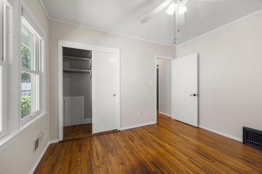 Sliding door closet of the first main level bedroom with plenty of shelving for extra storage