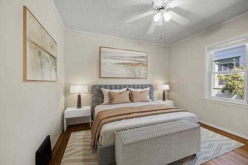 Main level first bedroom with hardwood flooring and natural light