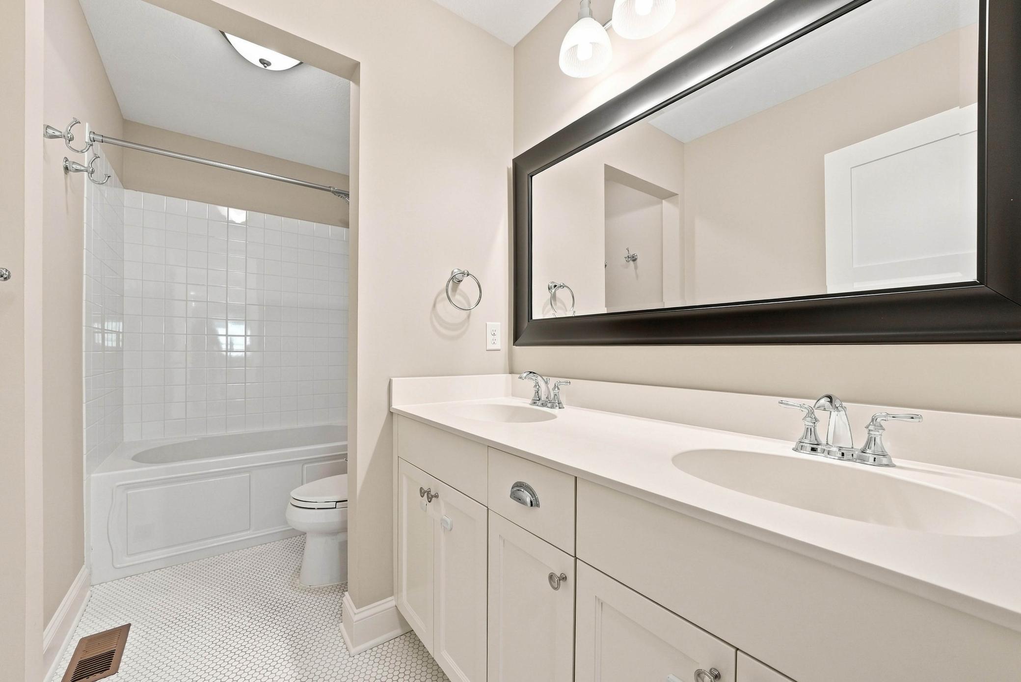 A beautifully appointed ensuite with dual vanities and timeless finishes.