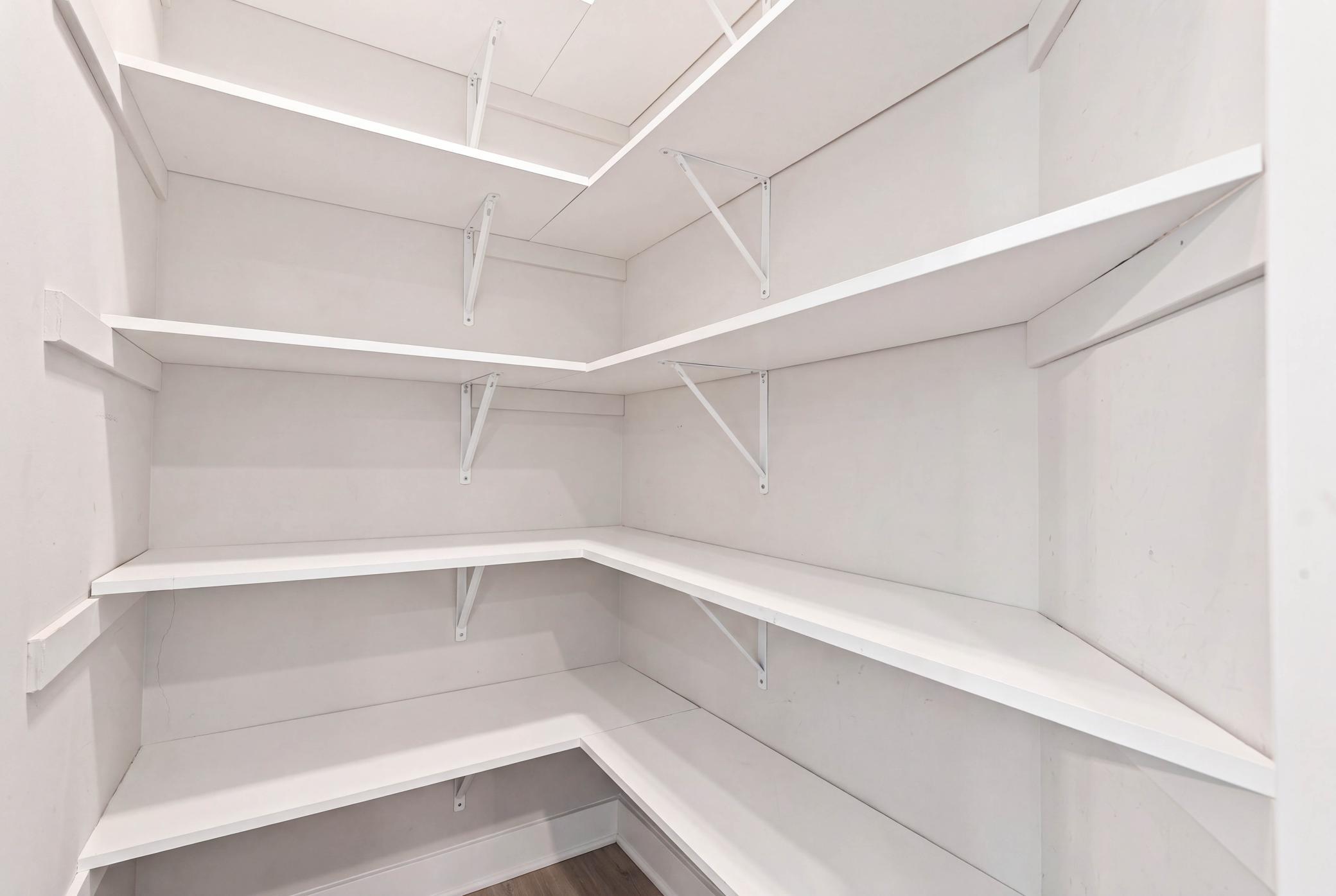 A spacious walk-in pantry keeps everything beautifully organized.