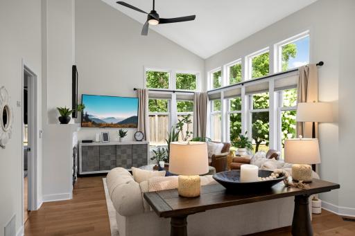 Beautiful open concept living room highlighted by dramatic vaulted ceilings and floor to ceiling windows.
