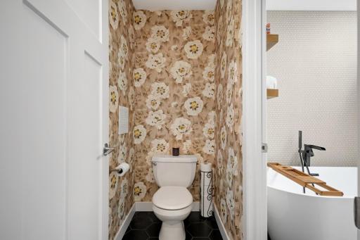 Private water closet with beautiful wallpaper.