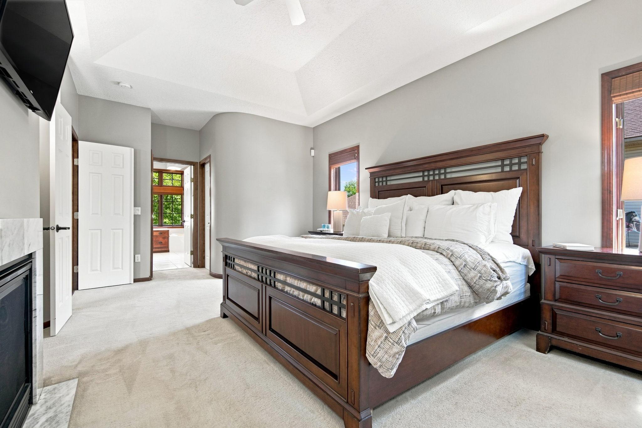 This view of the main floor primary bedroom looks toward the primary bath, with the closet conveniently positioned between them.