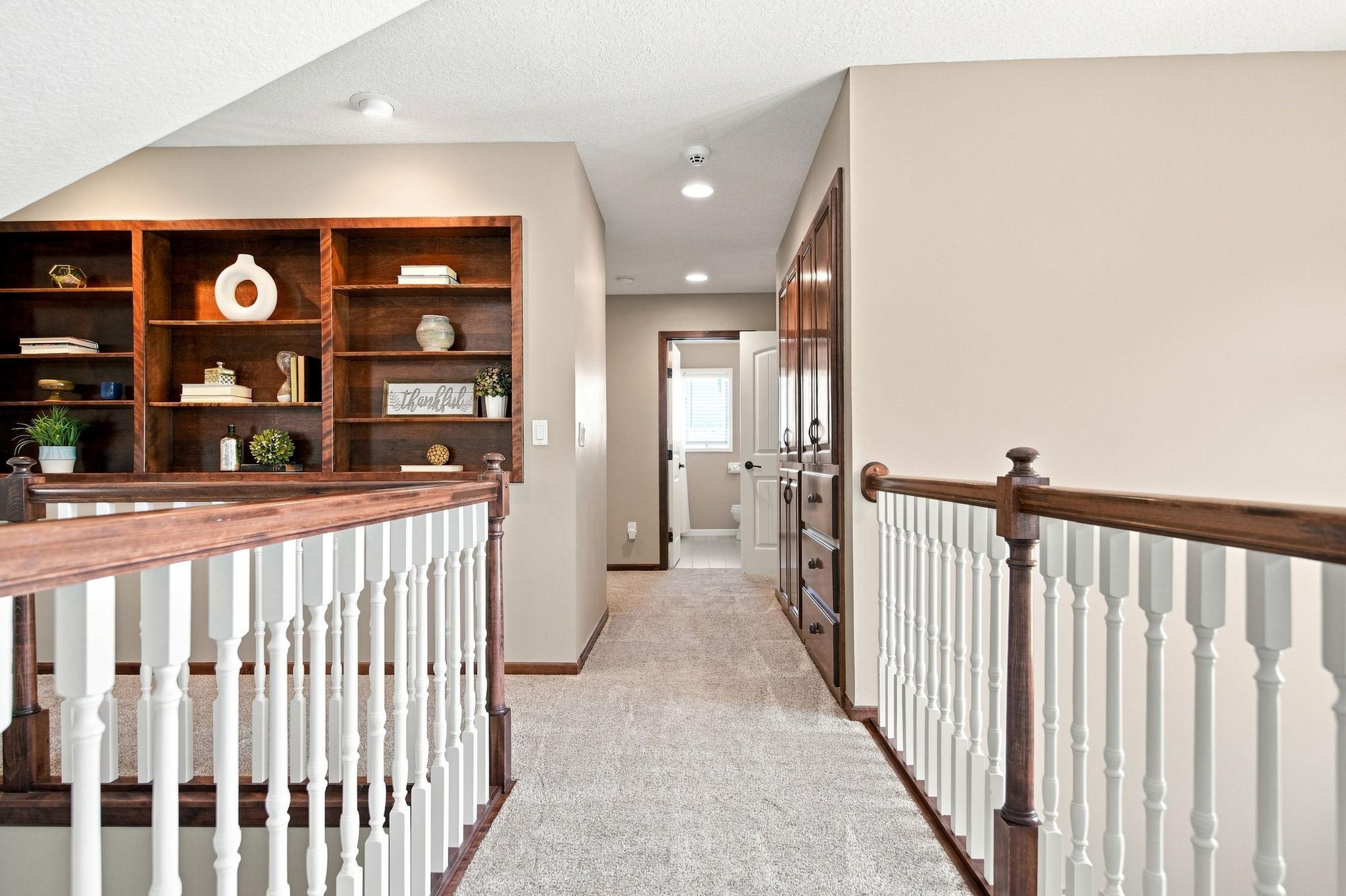 This view of the upper level features a custom-made inlaid wooden display case, a large linen closet, and new carpet throughout.