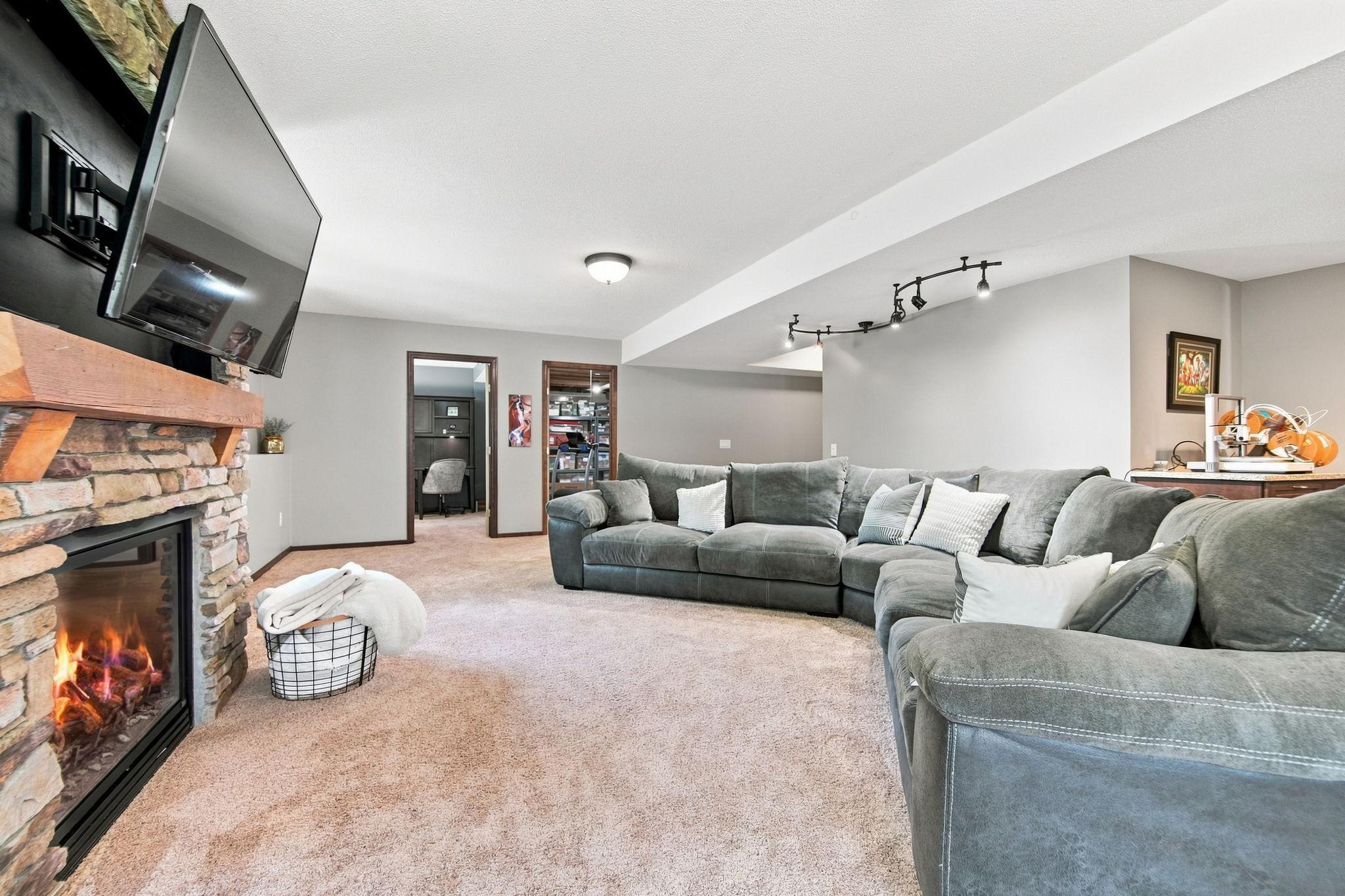 Another angle of the lower level shows off the fresh new carpet, light-filled daylight windows, and plenty of room to gather and entertain