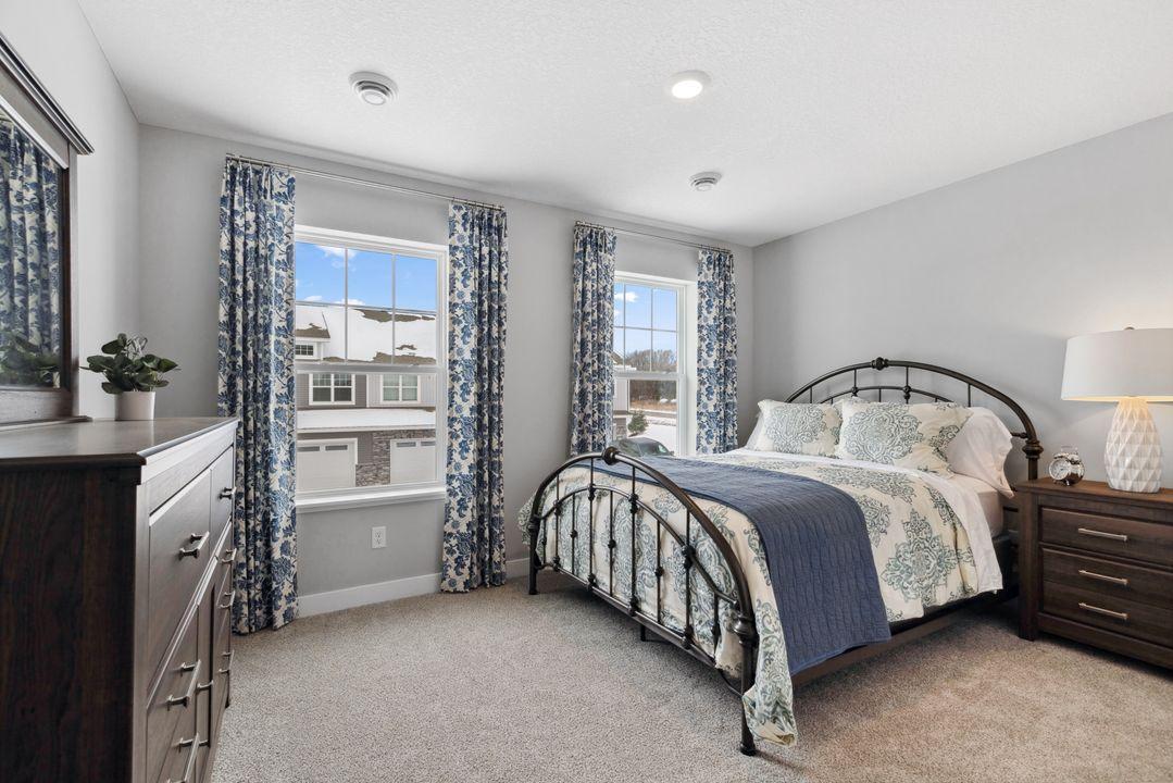 One of three spacious secondary bedrooms. Photo is of model home.