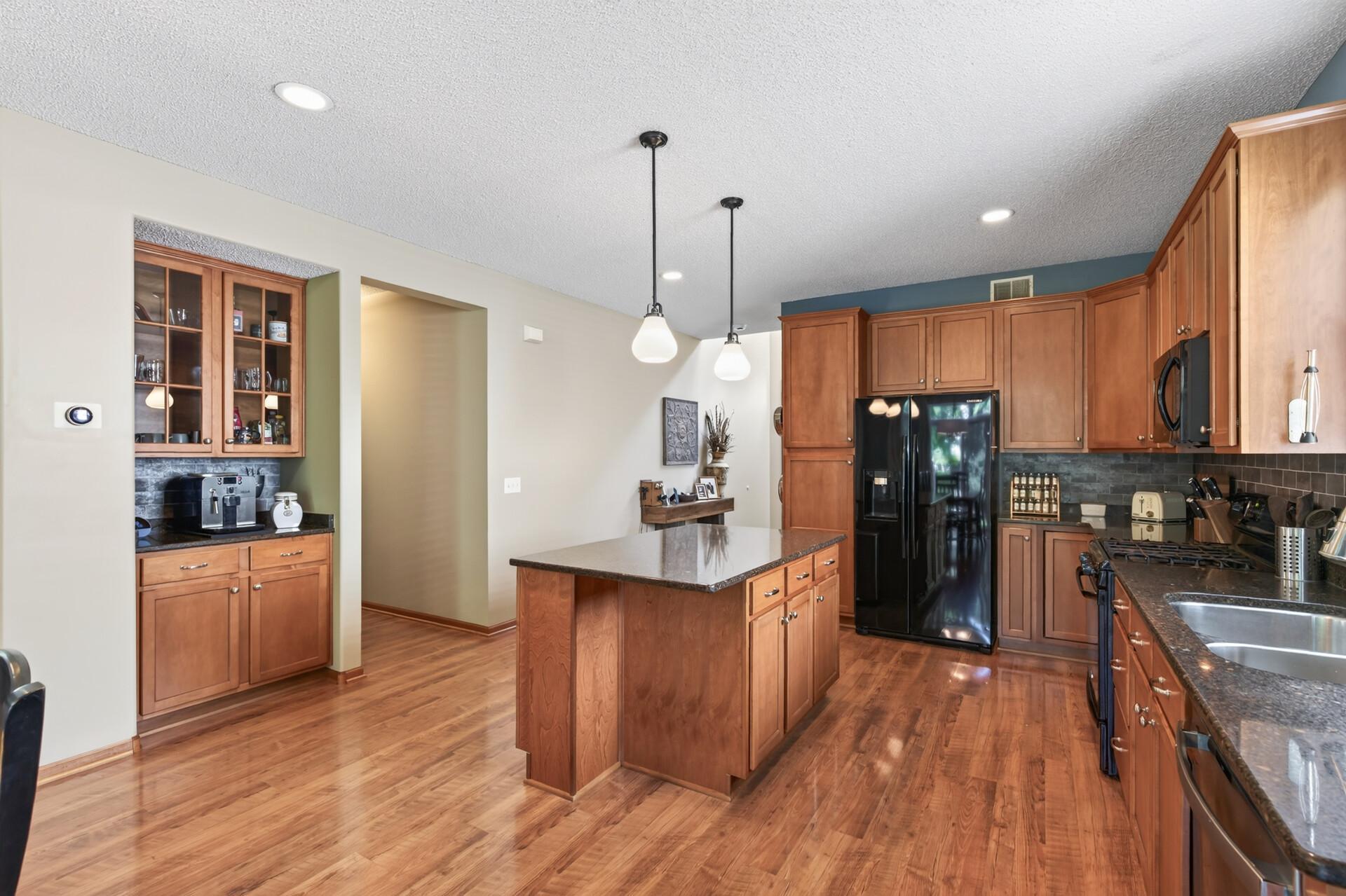 Another angle of the kitchen showing coffee bar and center island