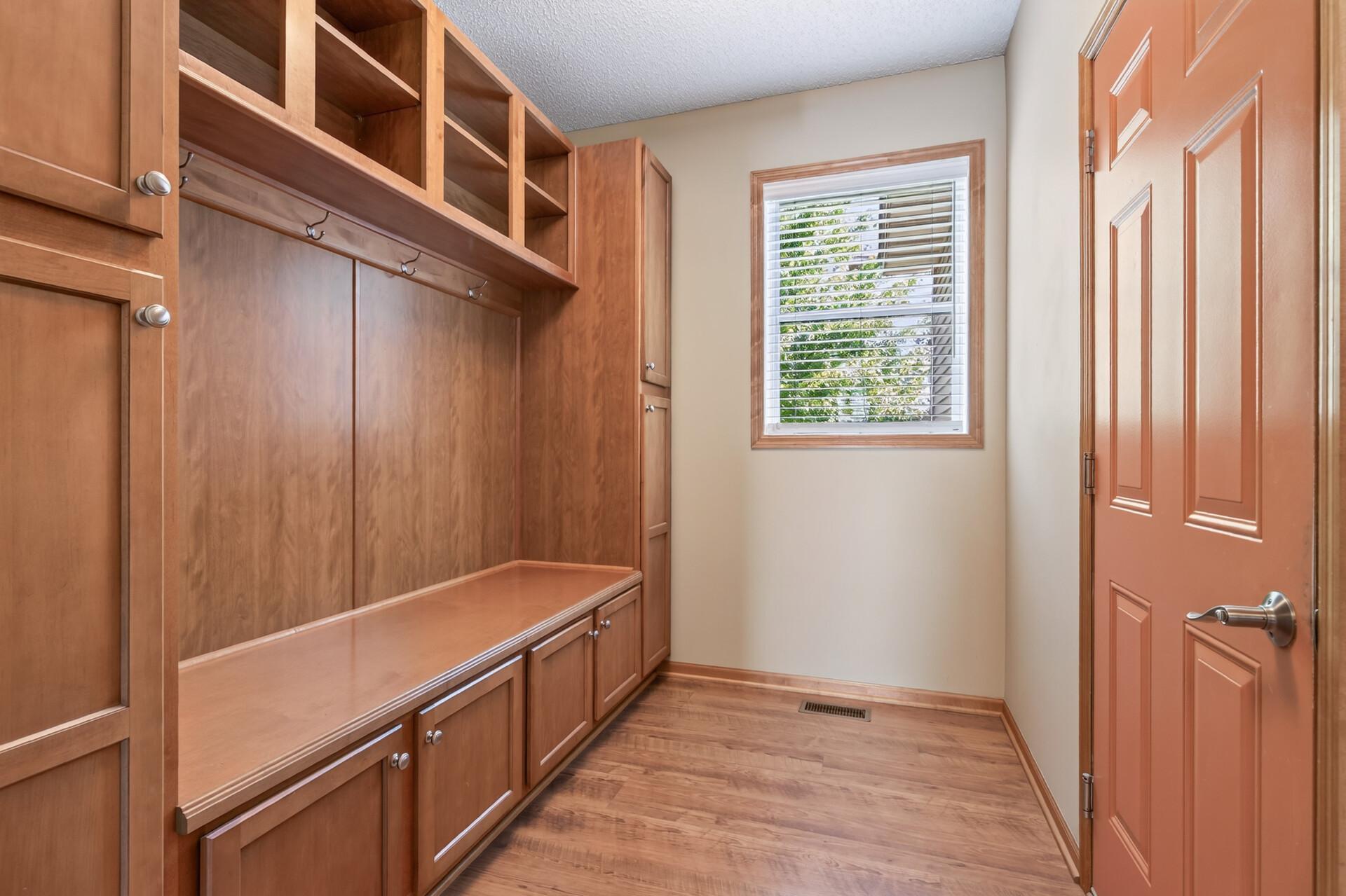 Mud room off the garage with bench and hooks