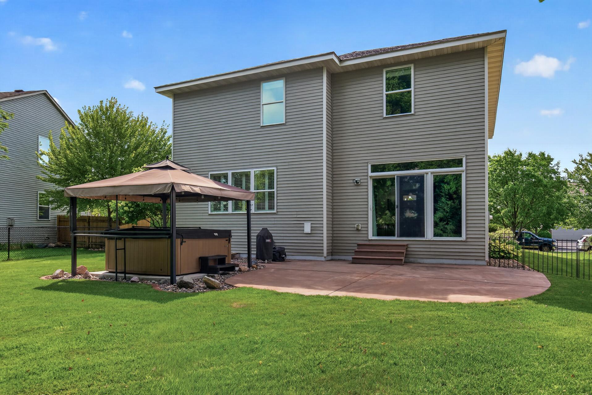 Back of home with stamped patio - and hot tub