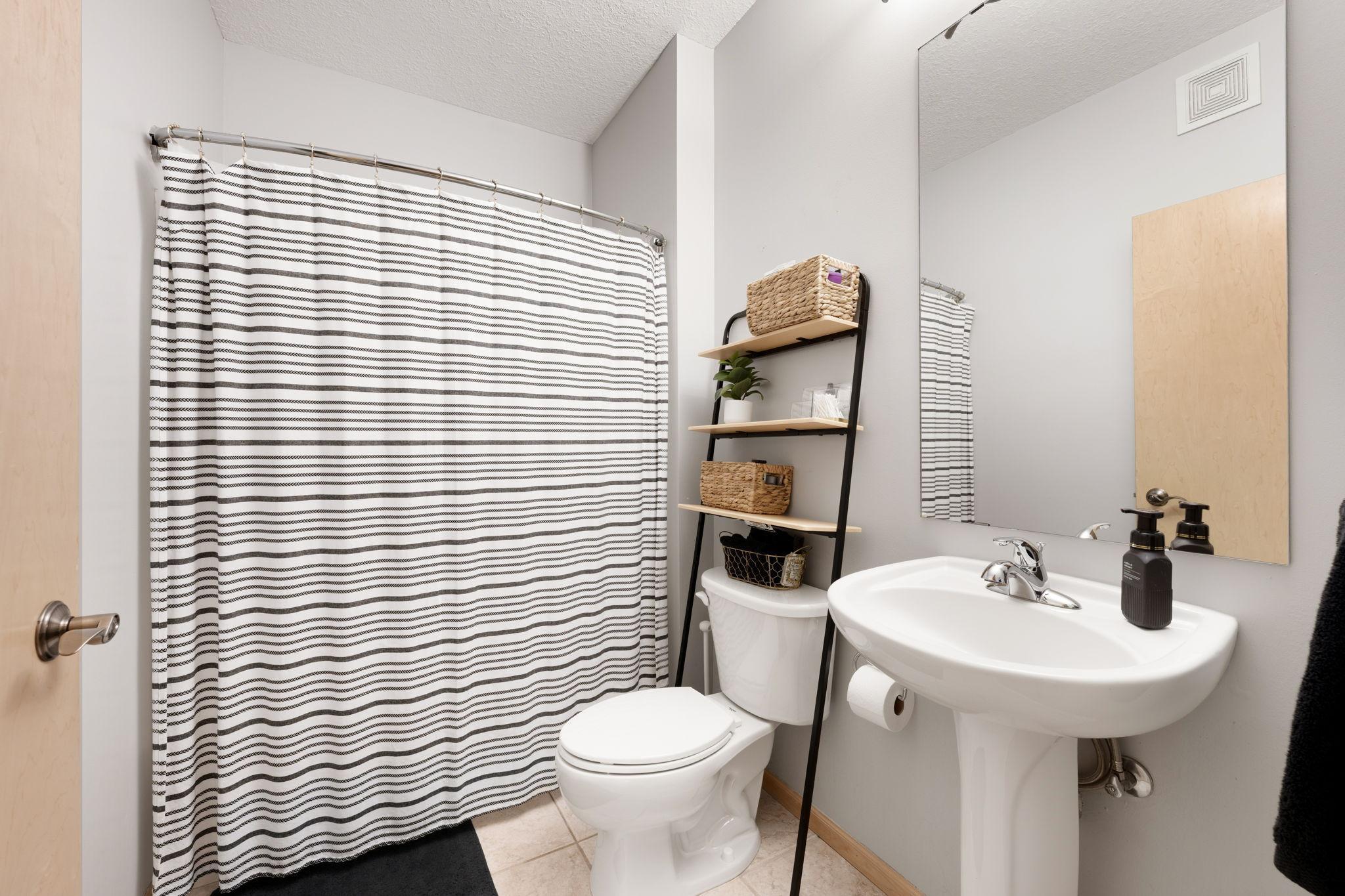 Full bath with neutral finishes, shower/tub combination, and functional layout.