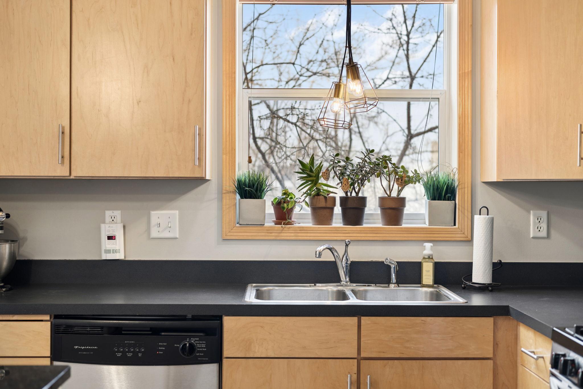 Window over the sink brings in natural light and highlights the kitchen’s clean finishes.