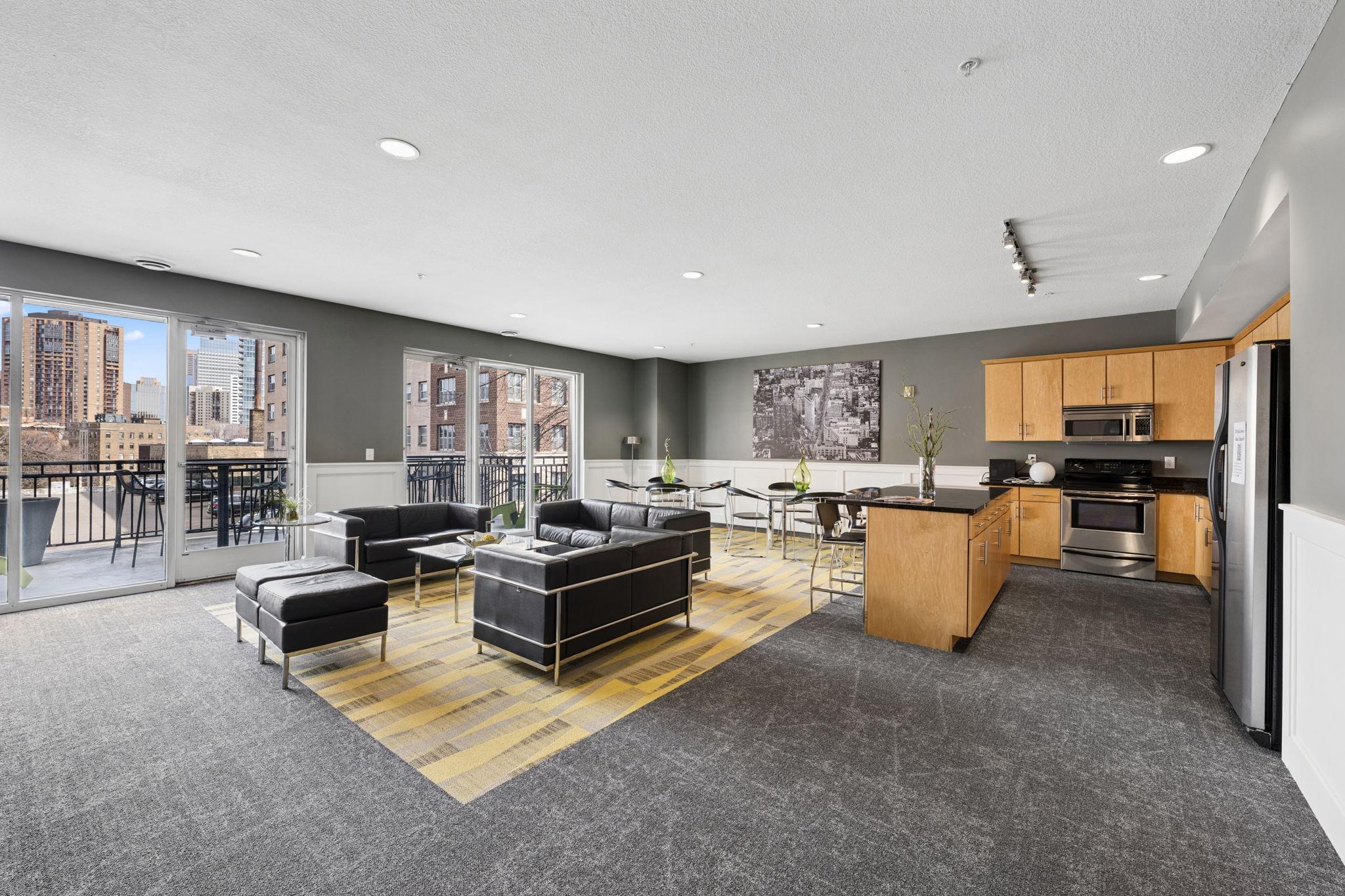 Stylish community room with lounge seating, kitchen area, and space for gatherings.