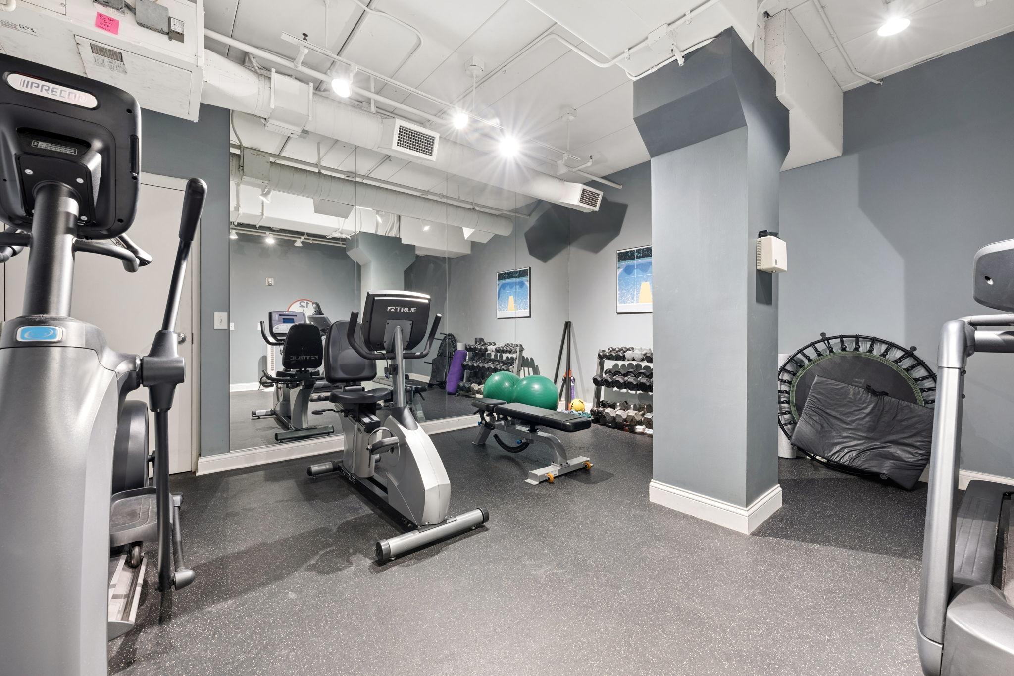 Fitness room with cardio equipment, weights, and space for everyday workouts.