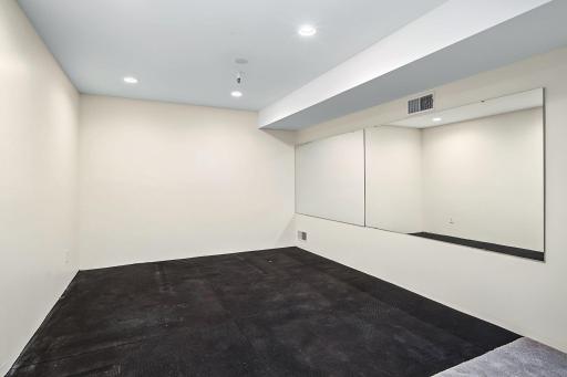 Dedicated exercise area with mirrored wall and resilient flooring