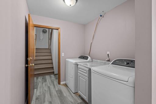 The lower-level laundry room features luxury plank flooring and a new washer and dryer (2021).