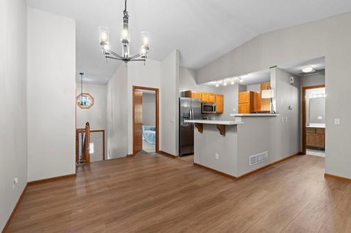The kitchen flows seamlessly into the dining area, highlighted by a classic hanging chandelier.