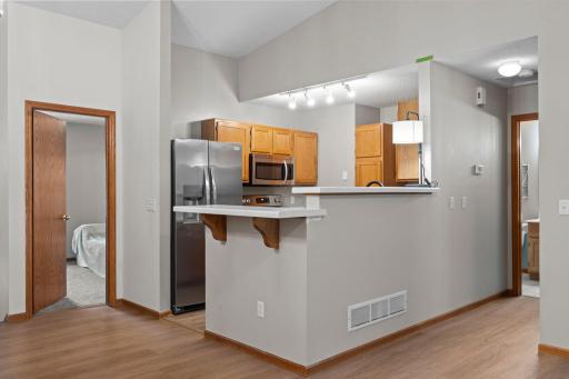 The kitchen features new luxury plank flooring, abundant wood cabinetry, updated countertops, and stainless steel appliances, including a new refrigerator and dishwasher (2025).