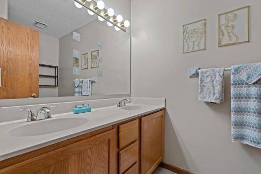 The private ensuite Â¾ bathroom featuring tile flooring, dual sinks, and a walk-in shower.