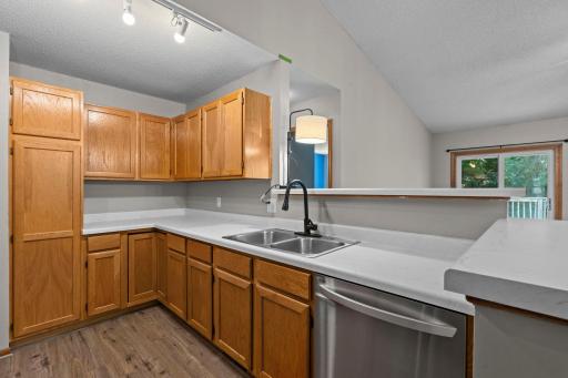 A closer look at the inviting kitchen showcasing generous storage, refreshed countertops, stainless steel appliances, and modern flooring.