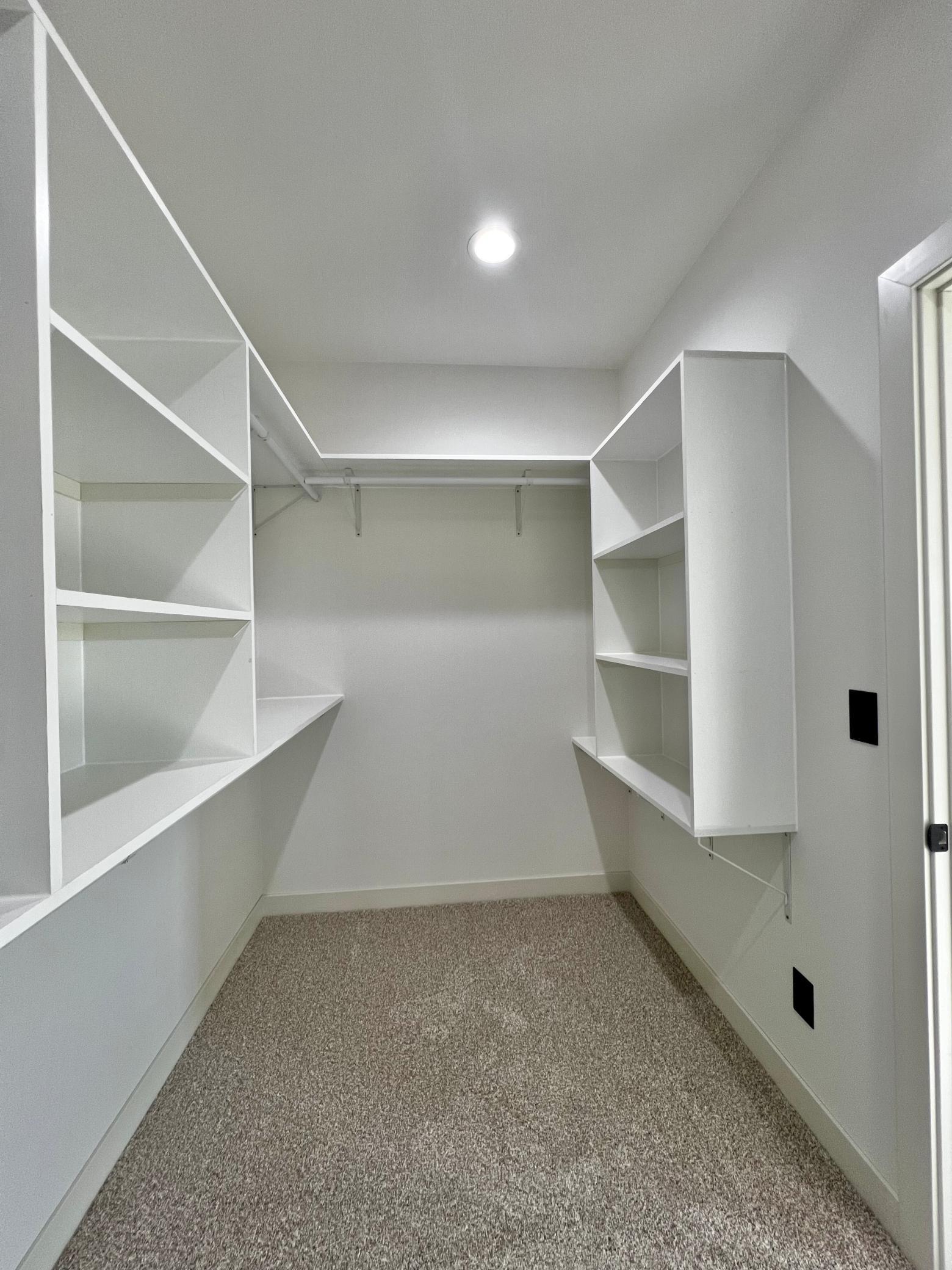 Primary Bedroom Walk in Closet with Custom Closet Systems.