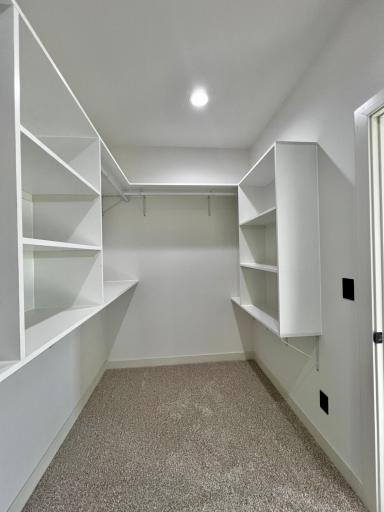 Primary Bedroom Walk in Closet with Custom Closet Systems.