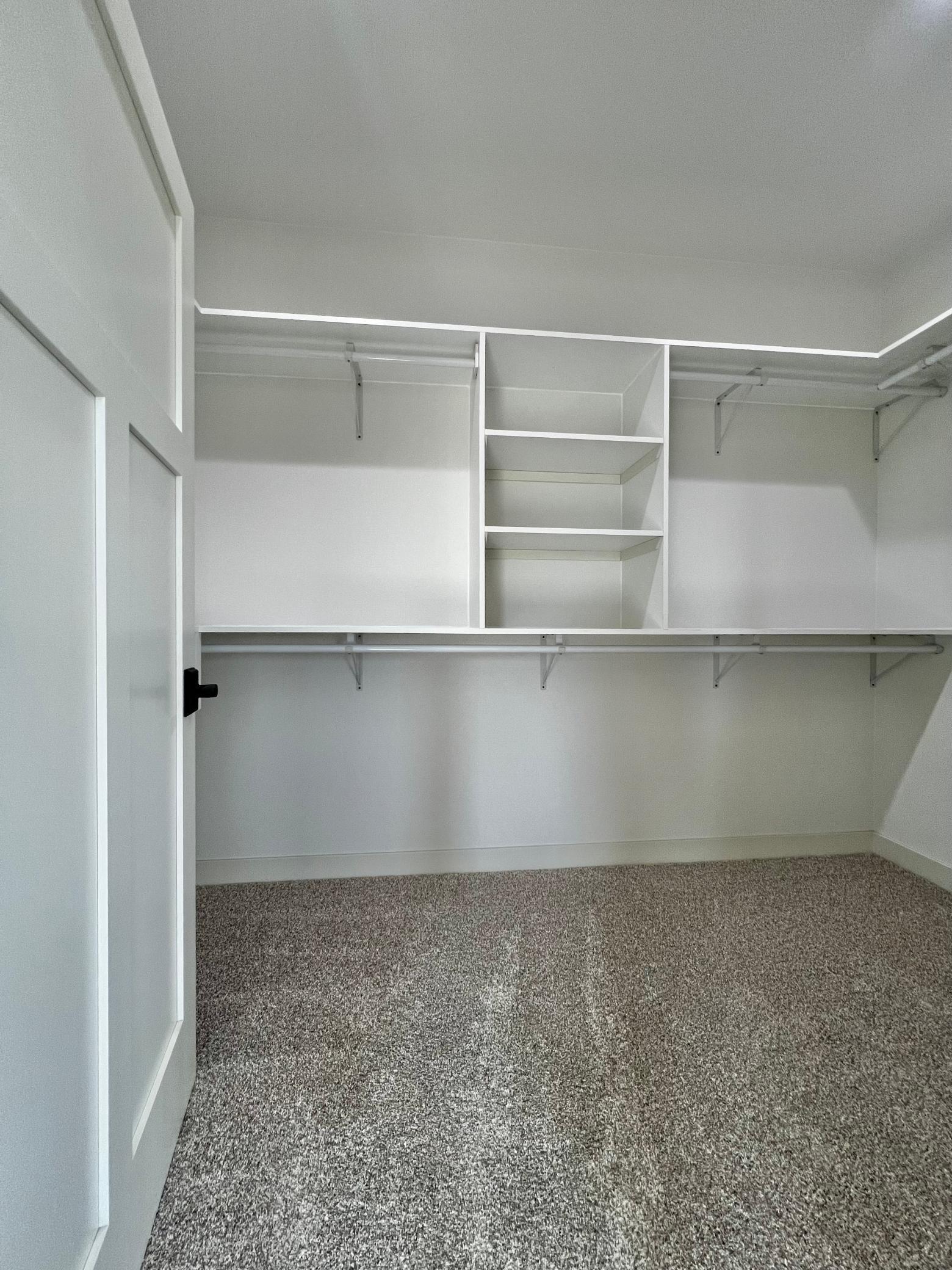 Primary Bedroom Walk in Closet with Custom Closet Systems.