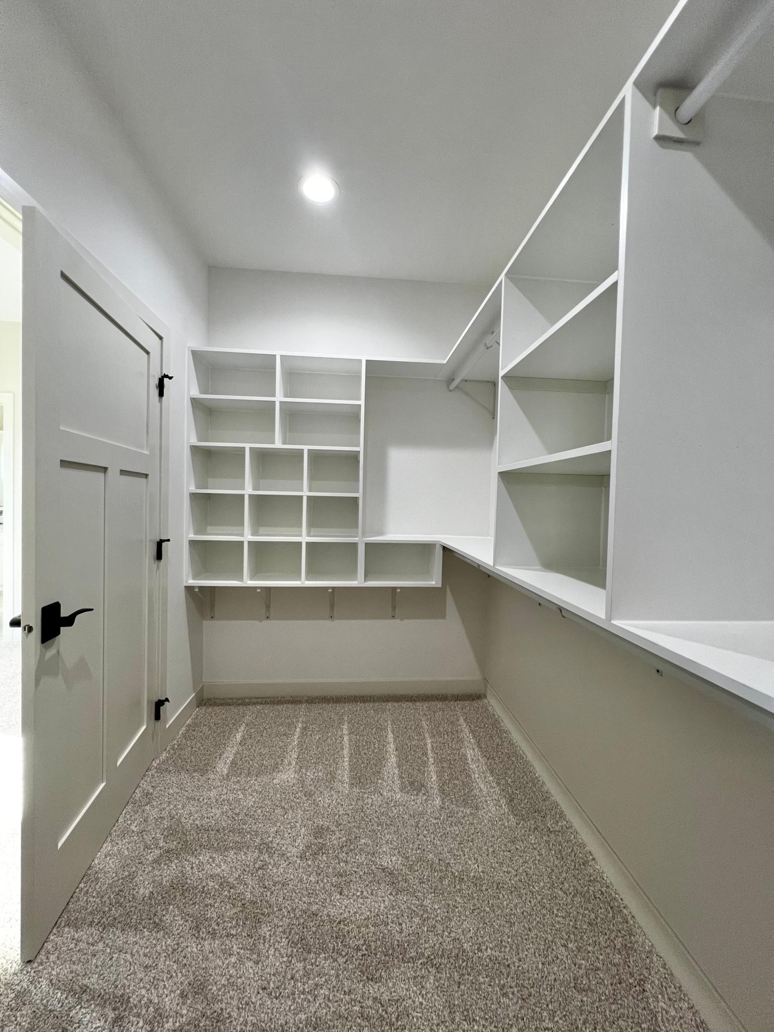 Primary Bedroom Walk in Closet with Custom Closet Systems.