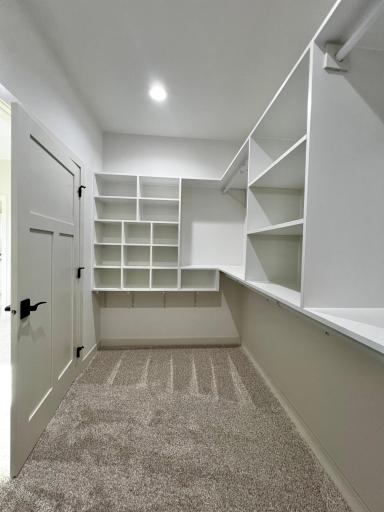 Primary Bedroom Walk in Closet with Custom Closet Systems.