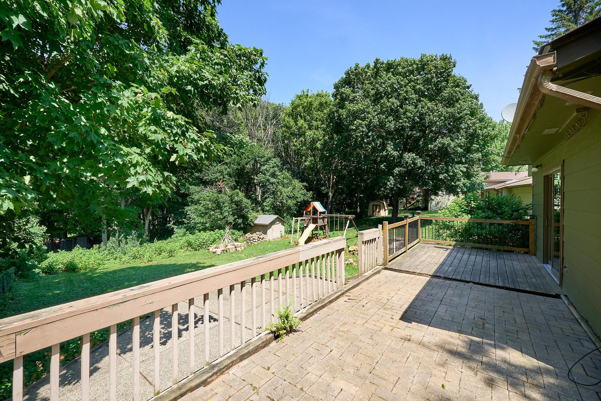 Brick patio, wood deck, lower patio, and beautiful fenced backyard.