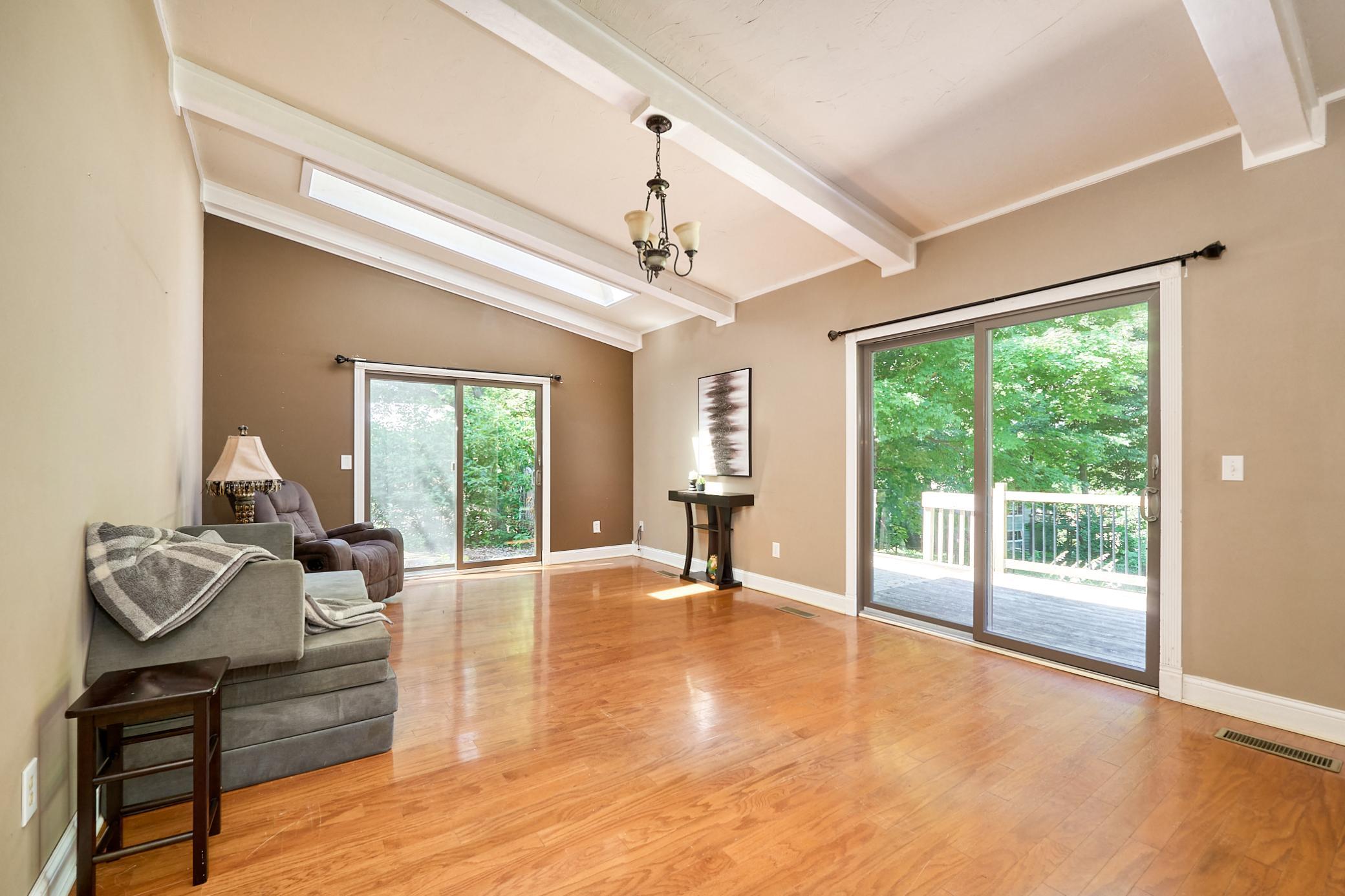 The vaulted family room is flooded with natural light from two patio sliders and a skylight.