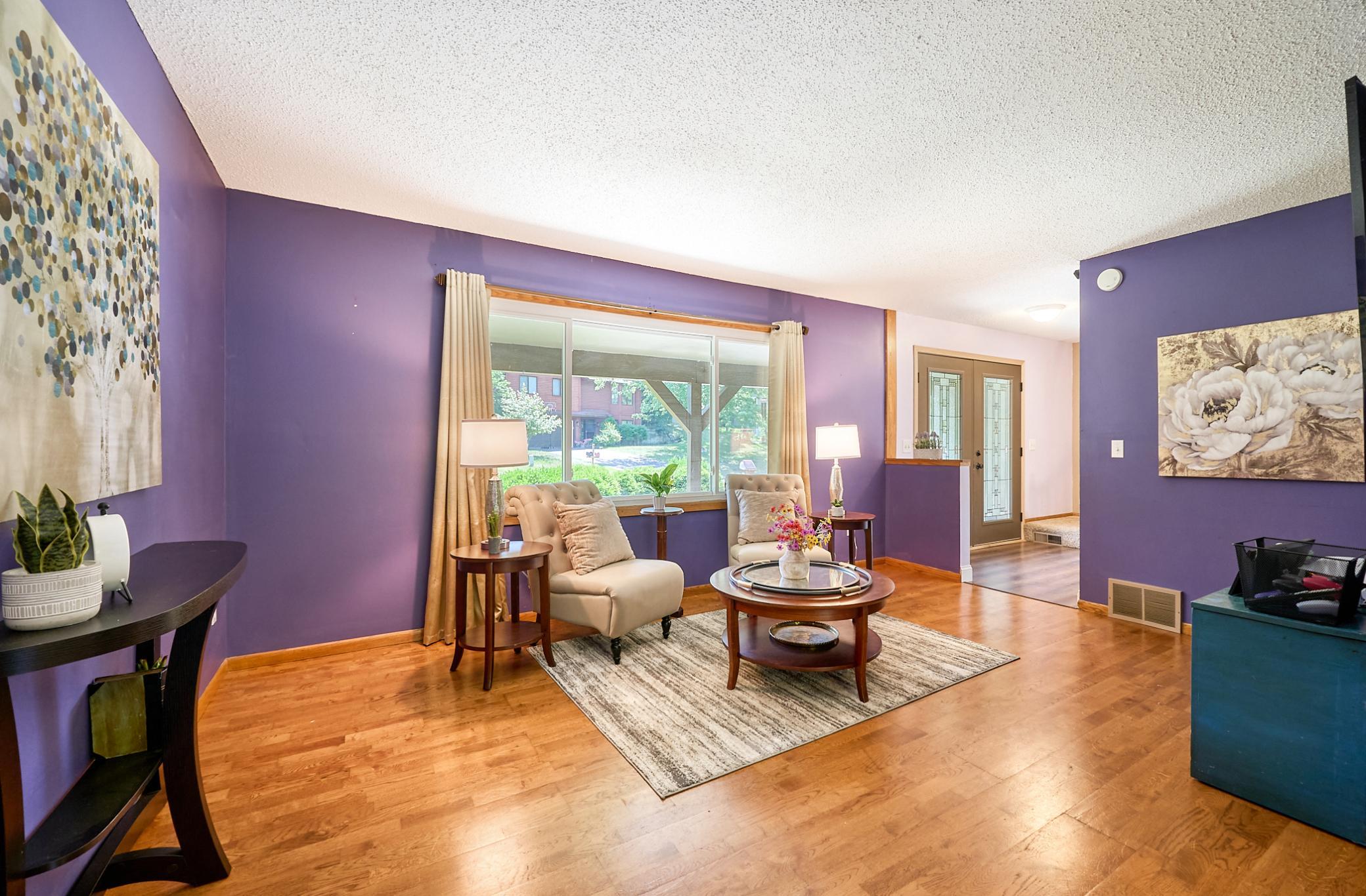 The living room is flooded with natural light through the new large windows.