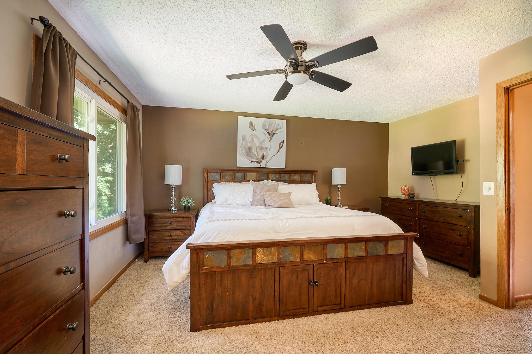 Spacious upper-level primary suite overlooks the park-like backyard