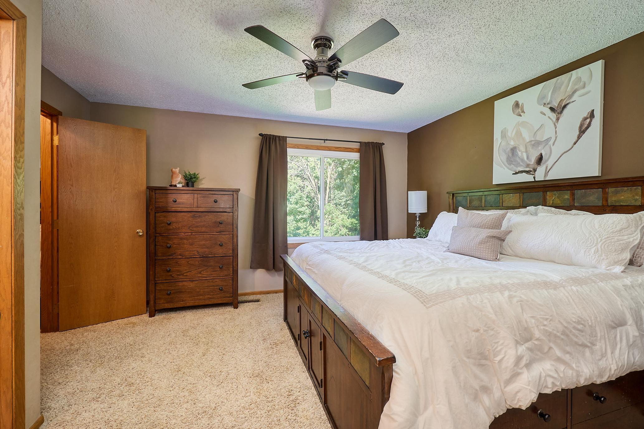 Spacious upper-level primary suite overlooks the park-like yard.