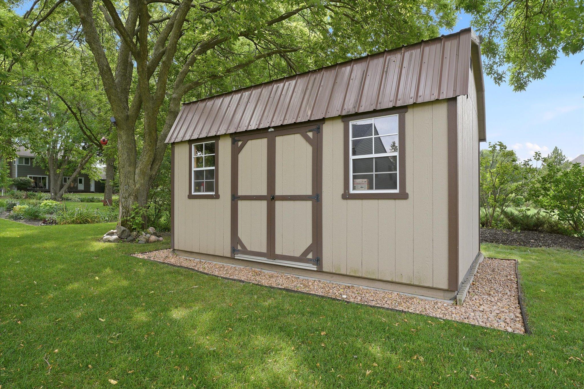 Newer storage shed at the back of the yard provides ample storage for winter storage and lawn and garden equipment