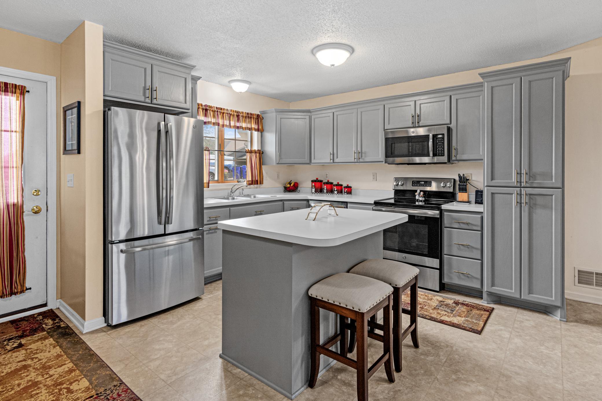 A kitchen window, generous cabinetry, and stainless appliances