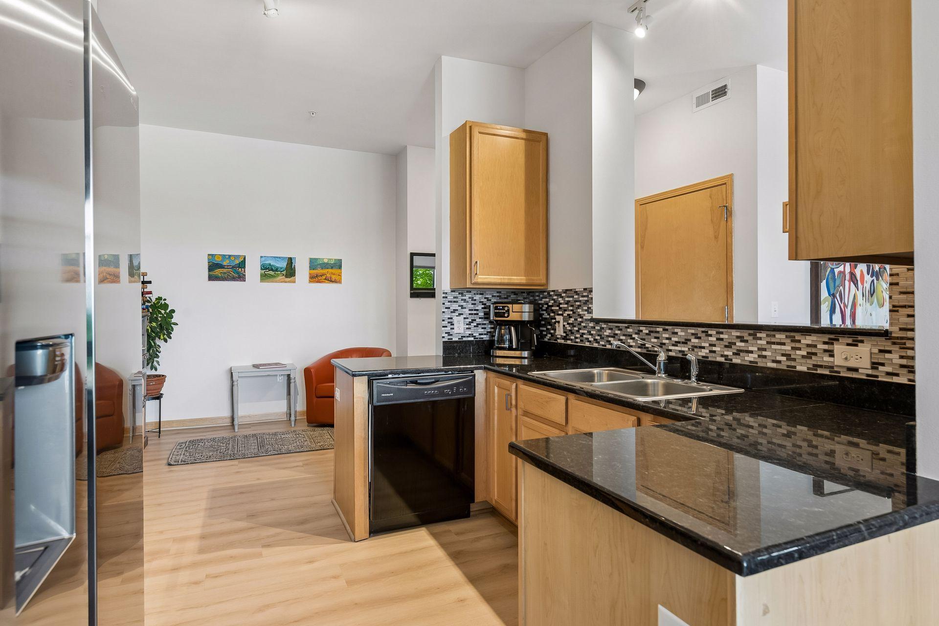 The stainless refrigerator is on the left. The closed door seen through the opening is a half bath.