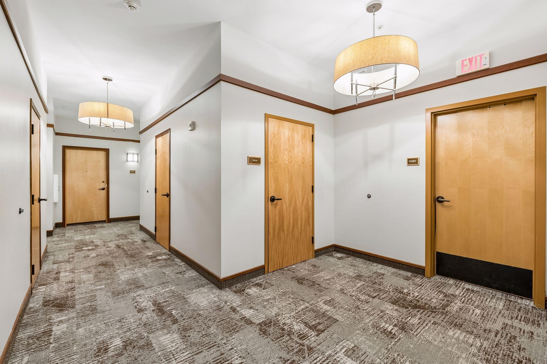 More location convenience! The condo door is on the right. The two forefront doors are Refuse and Stairwell. No long halls to get to the trash or your parking spot in the garage.