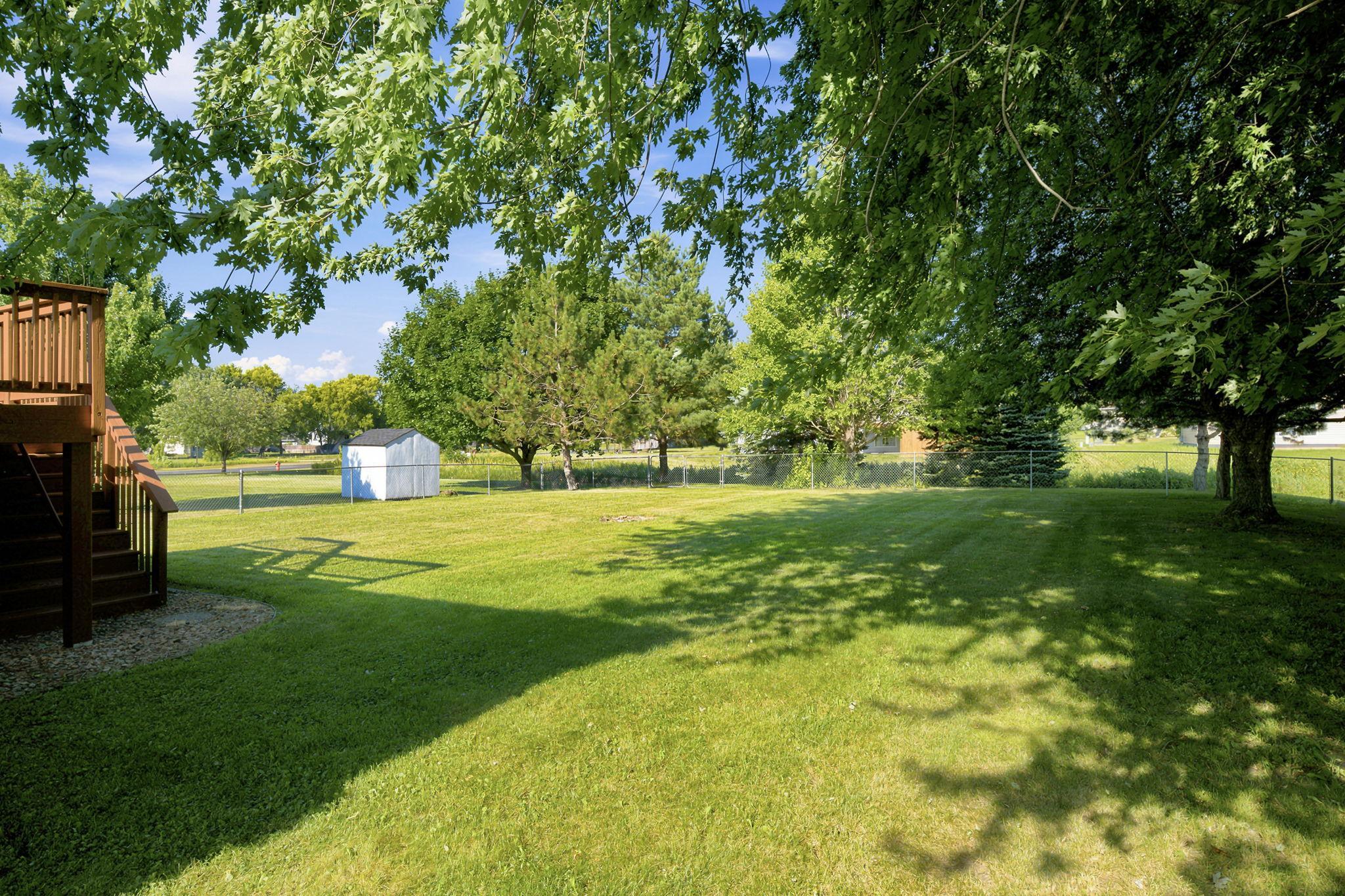 Expansive, fenced in backyard with mature trees.