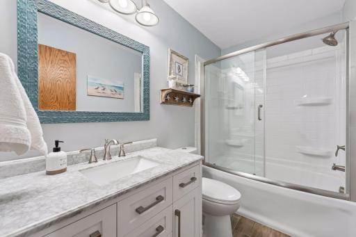 Full bath with updated vanity and flooring.