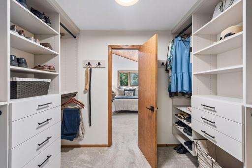 Primary bedroom walk-in closet with organizers.