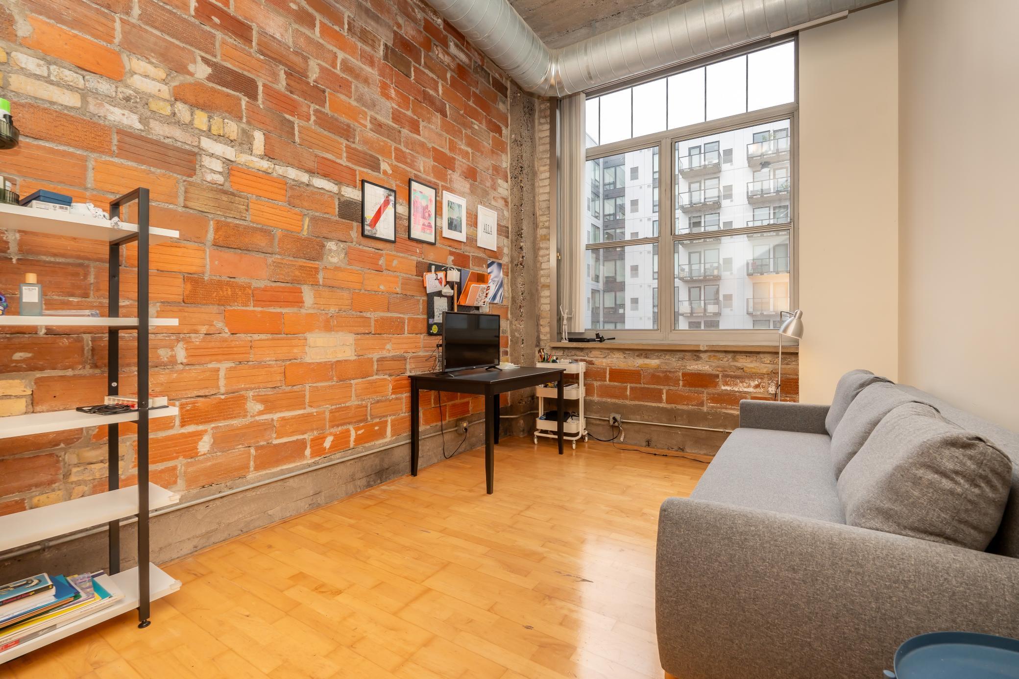 Bedroom #2 - continues with the industrial look with hardwood flooring and this beautiful tall window
